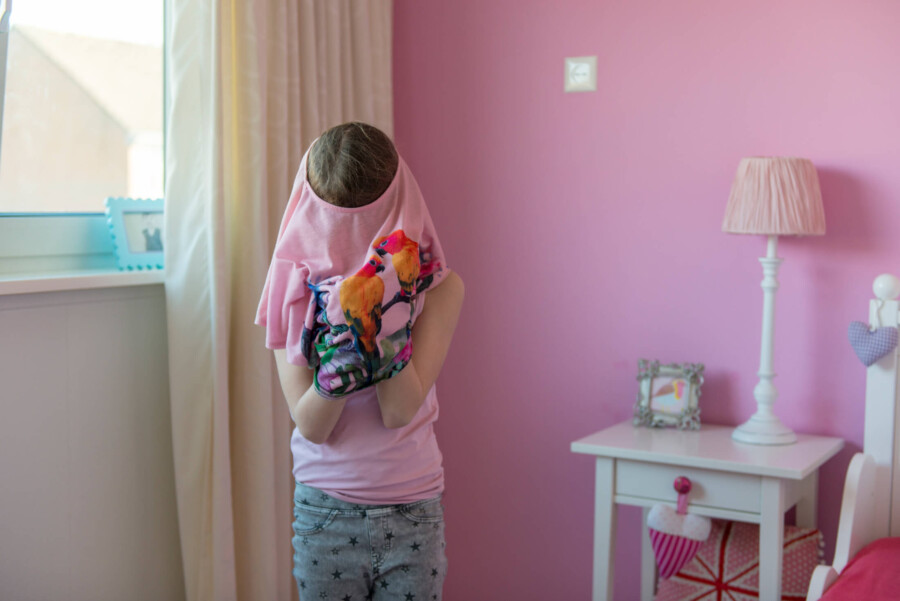 Nederland, 14-02-2019 - Een meisje kleedt zich om na schooltijd, omdat het heel mooi weer is en ze graag iets met korte mouwen aan wilt. foto: Patricia Rehe / Hollandse Hoogte