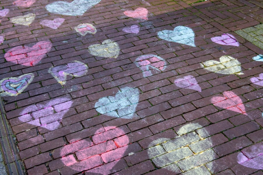 Nederland, Nijmegen, 26-03-2020 - Op de stoep in de binnenstad van Nijmegen heeft iemand allemaal gekleurde hartjes getekent. Een vrolijk en lief beeld in een lege winkelstraat. foto: Patricia Rehe / Hollandse Hoogte
